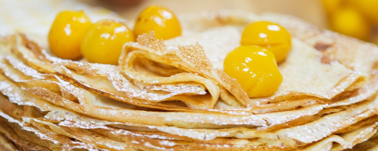 pile de crêpes surmontée de mirabelles au sirop